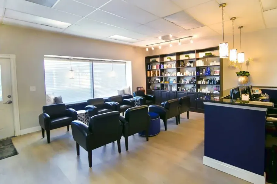 Reception area with black chairs, product shelves, and a reception desk.