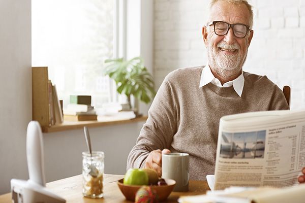 elderly person reading a newspaper