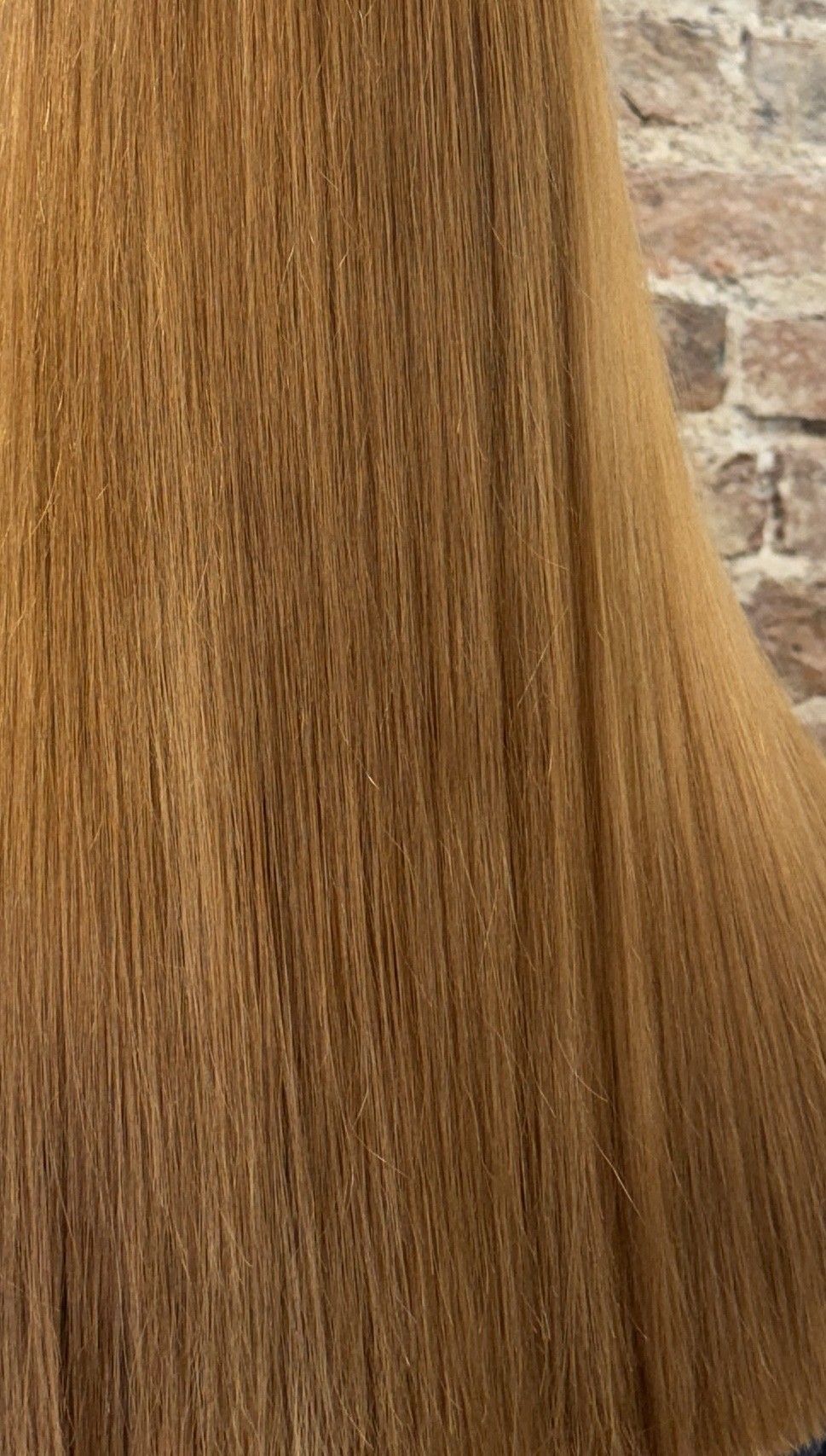 Back view of long hair with a warm copper-gold colour after the first correction session