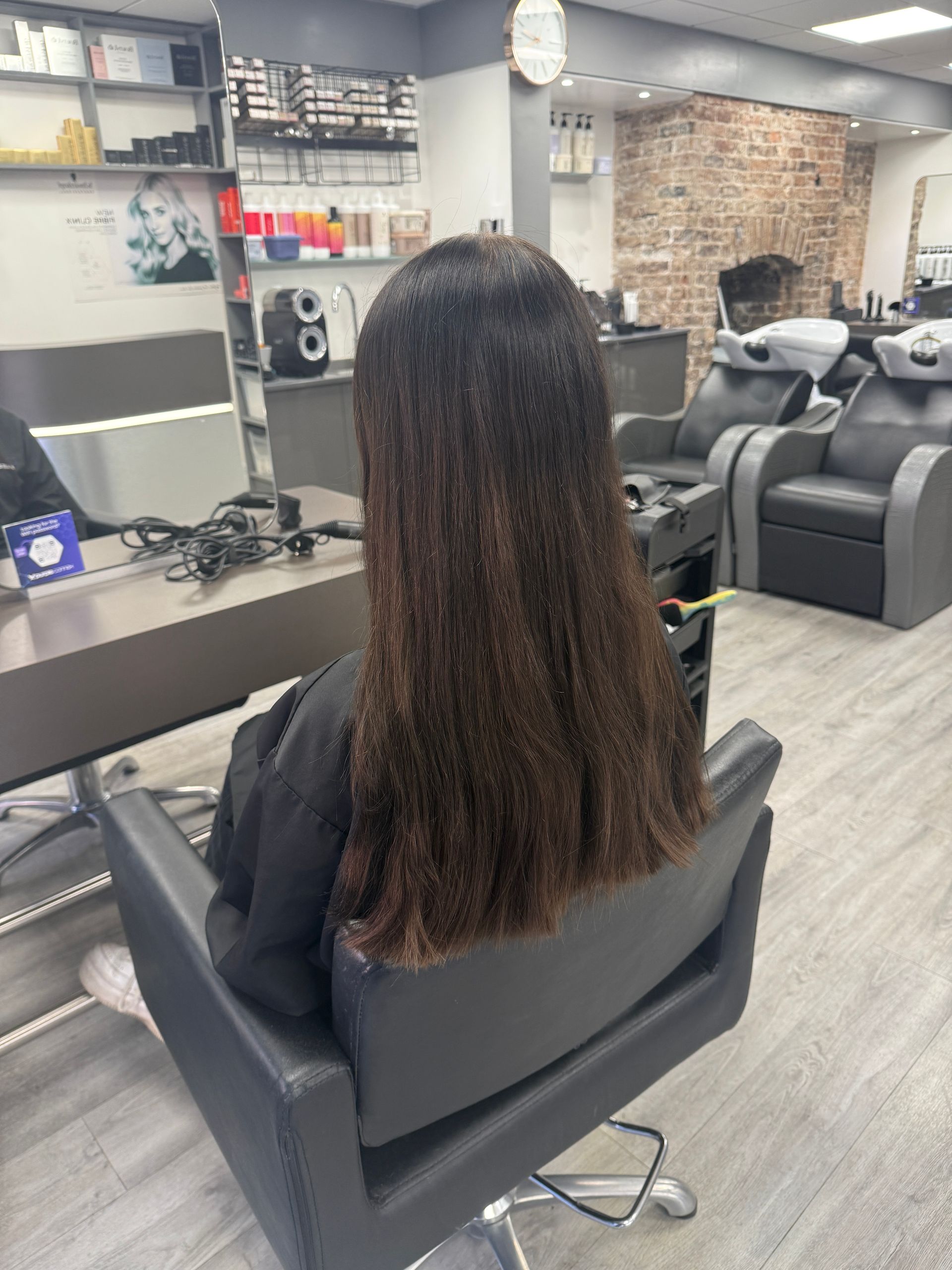 Uneven dark hair colour with visible build-up before colour correction in salon