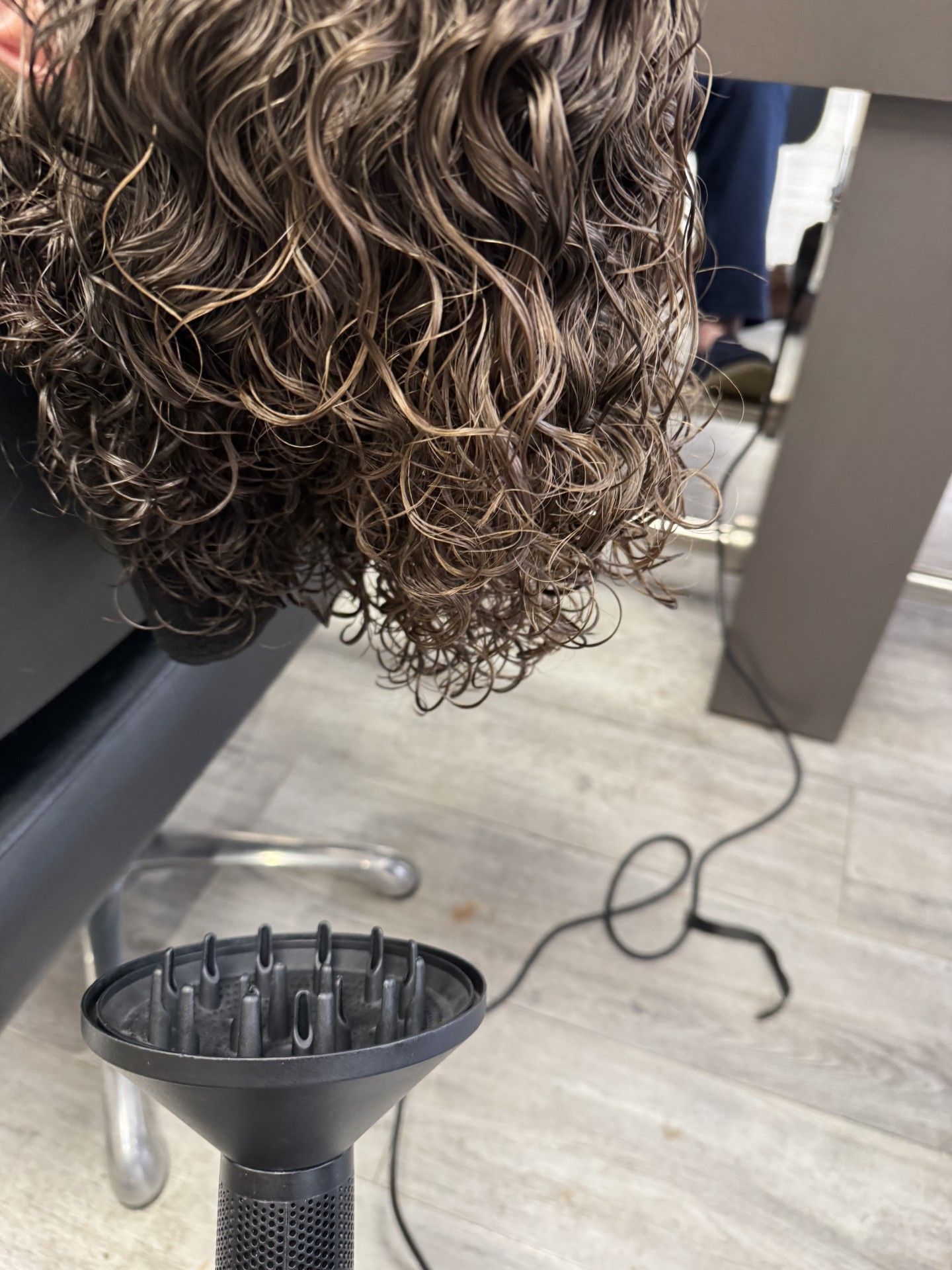 Freshly permed curls being diffused dry in salon