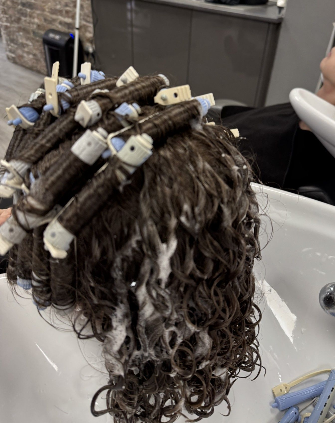 Perm rods being removed during a professional curl service