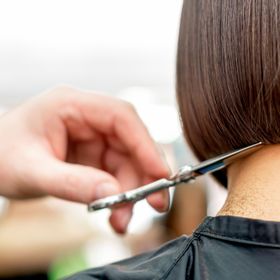 Hairdresser cutting hair with scissors during precision haircut at THE TRUTH IN COLOUR™ salon Newcastle
