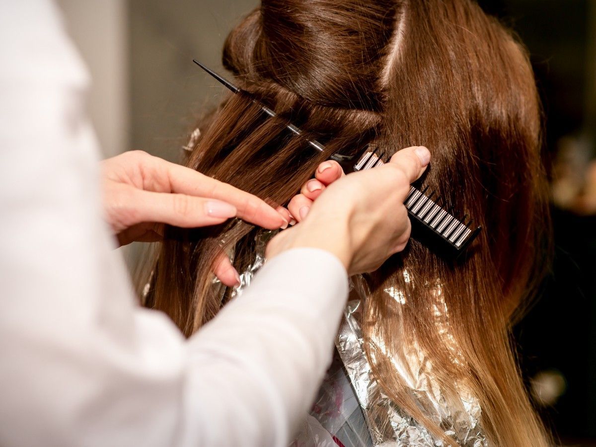 Professional hair colour sectioning and foil placement during a salon colour service