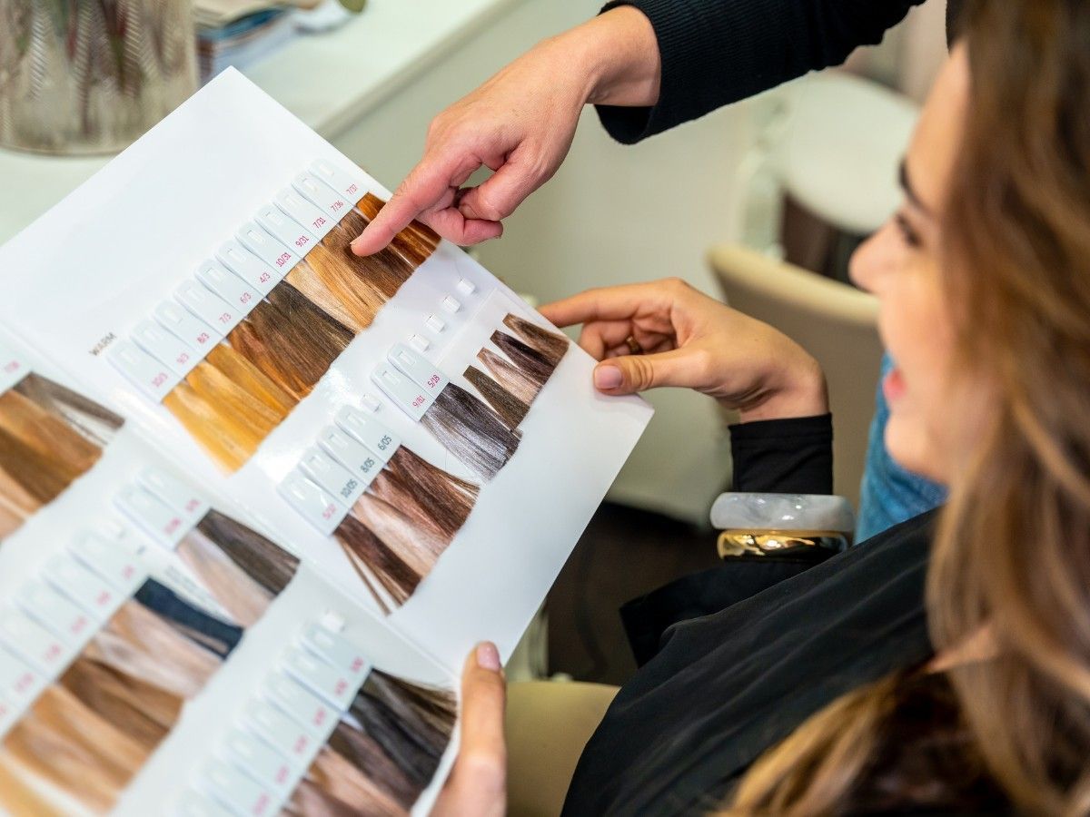 Client and stylist reviewing hair colour options during a consultation