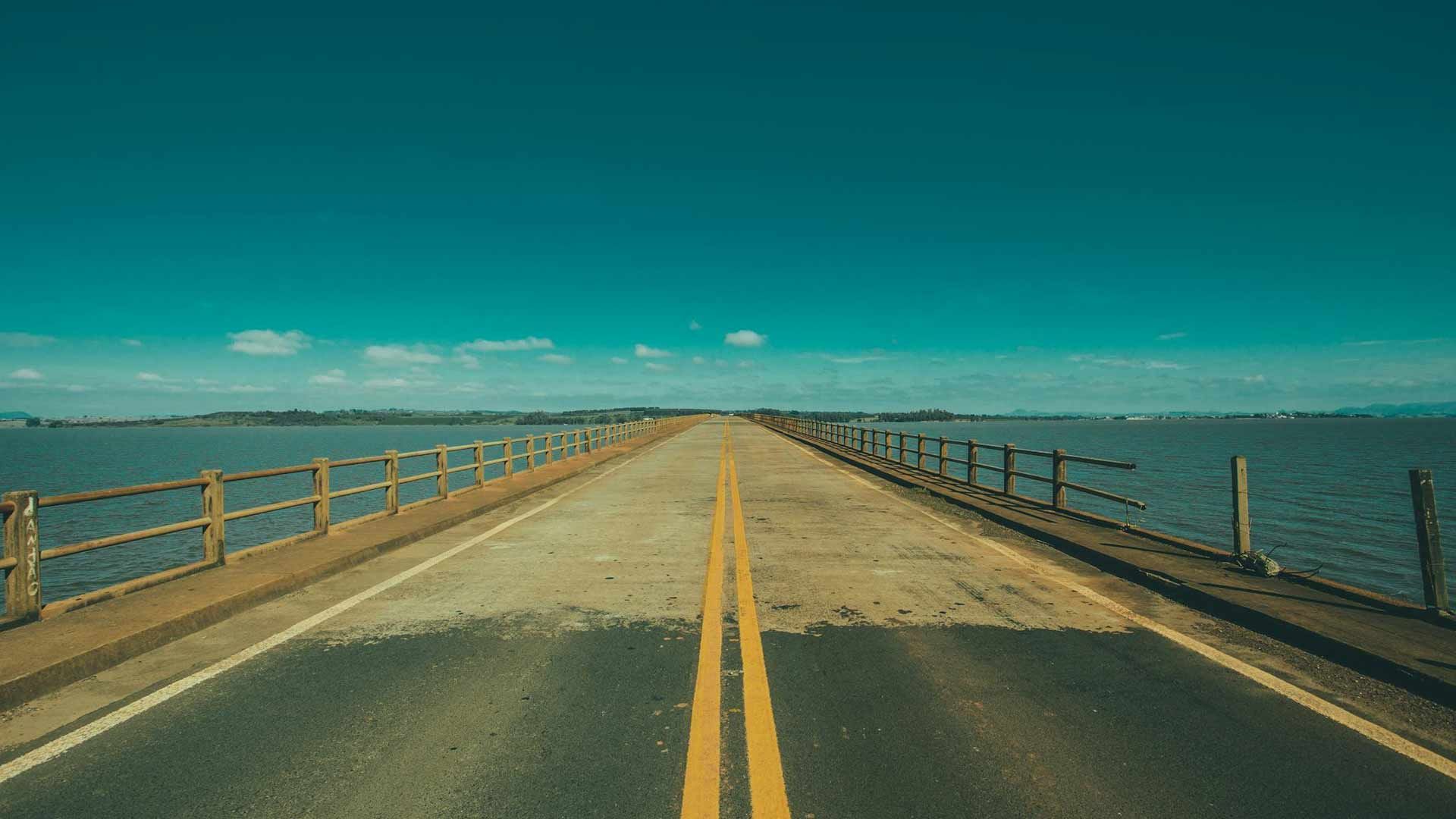 A bridge over a body of water with a road going over it.