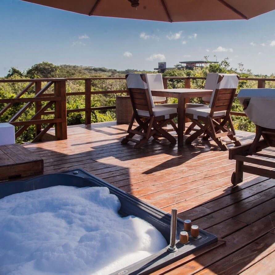 Un deck con mesa y sillas y jacuzzi