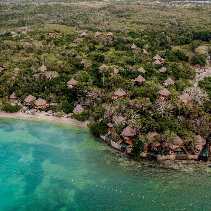 Una vista aérea de un resort en una pequeña isla en medio del océano.