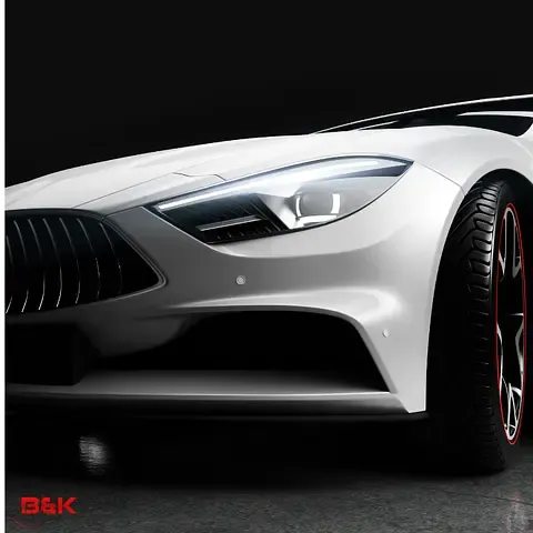 Close-up of a sleek white sports car’s front end, featuring a grille, LED headlight, and black wheels with red accents.