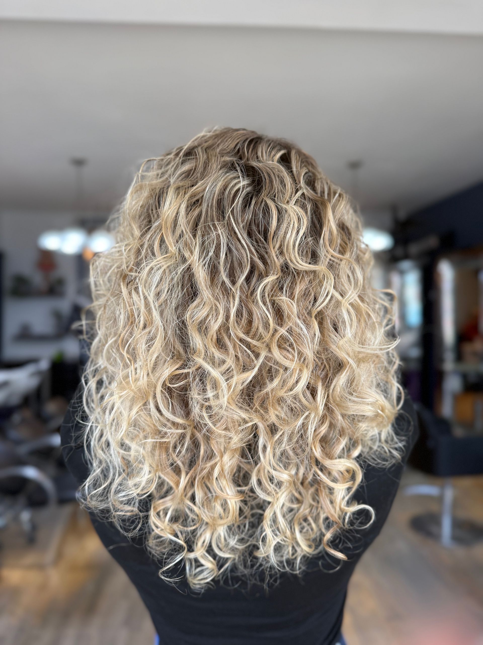 Long blonde natural curls photographed from behind in The Pamper Lounge salon