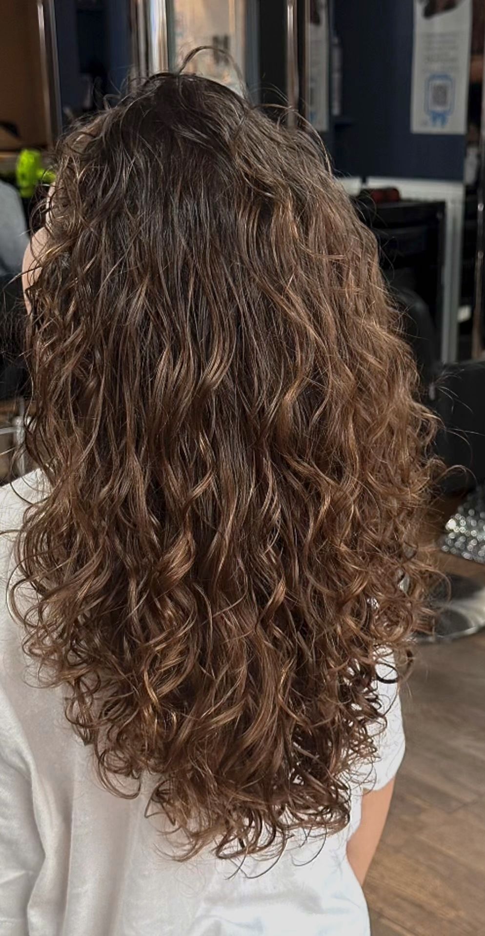 Young client with long dark natural curls, photographed from behind at The Pamper Lounge