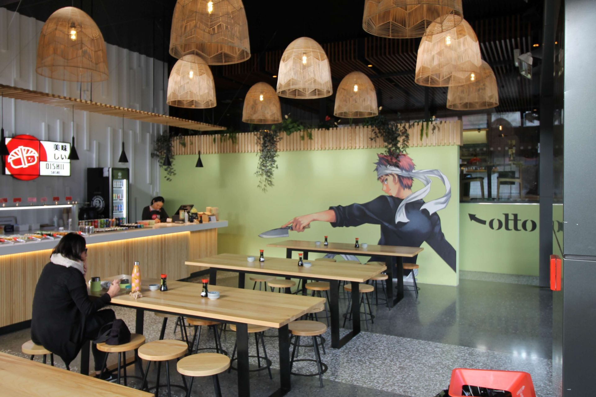 A woman is sitting at a table in a restaurant. Statement Homes Christchurch