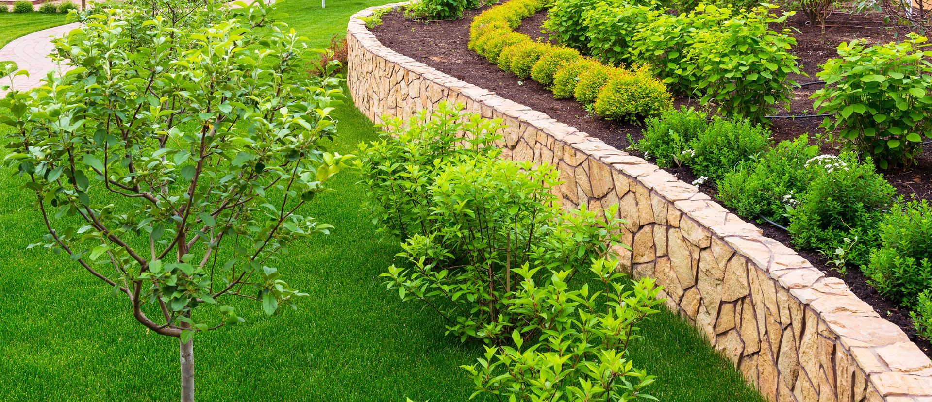 There is a stone wall in the middle of the garden.