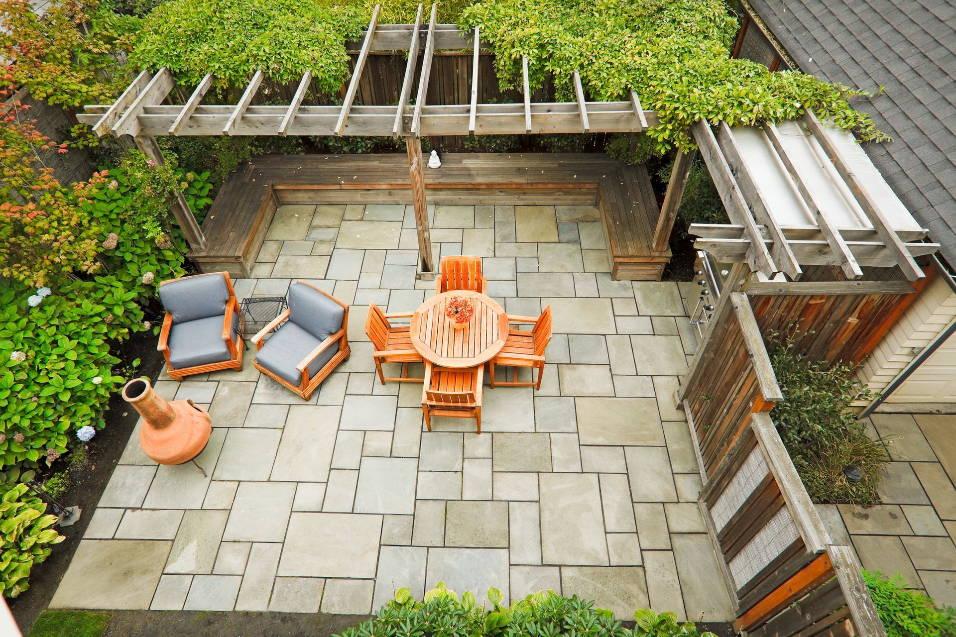 An aerial view of a patio with a table and chairs under a pergola