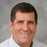A man in a striped shirt is smiling for the camera.