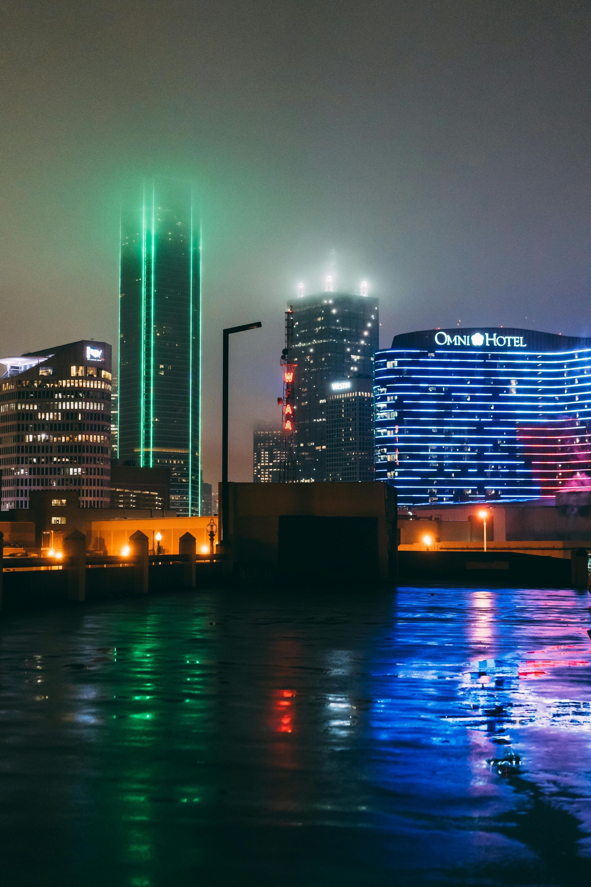 A yellow boat is floating down a river in front of a city skyline.