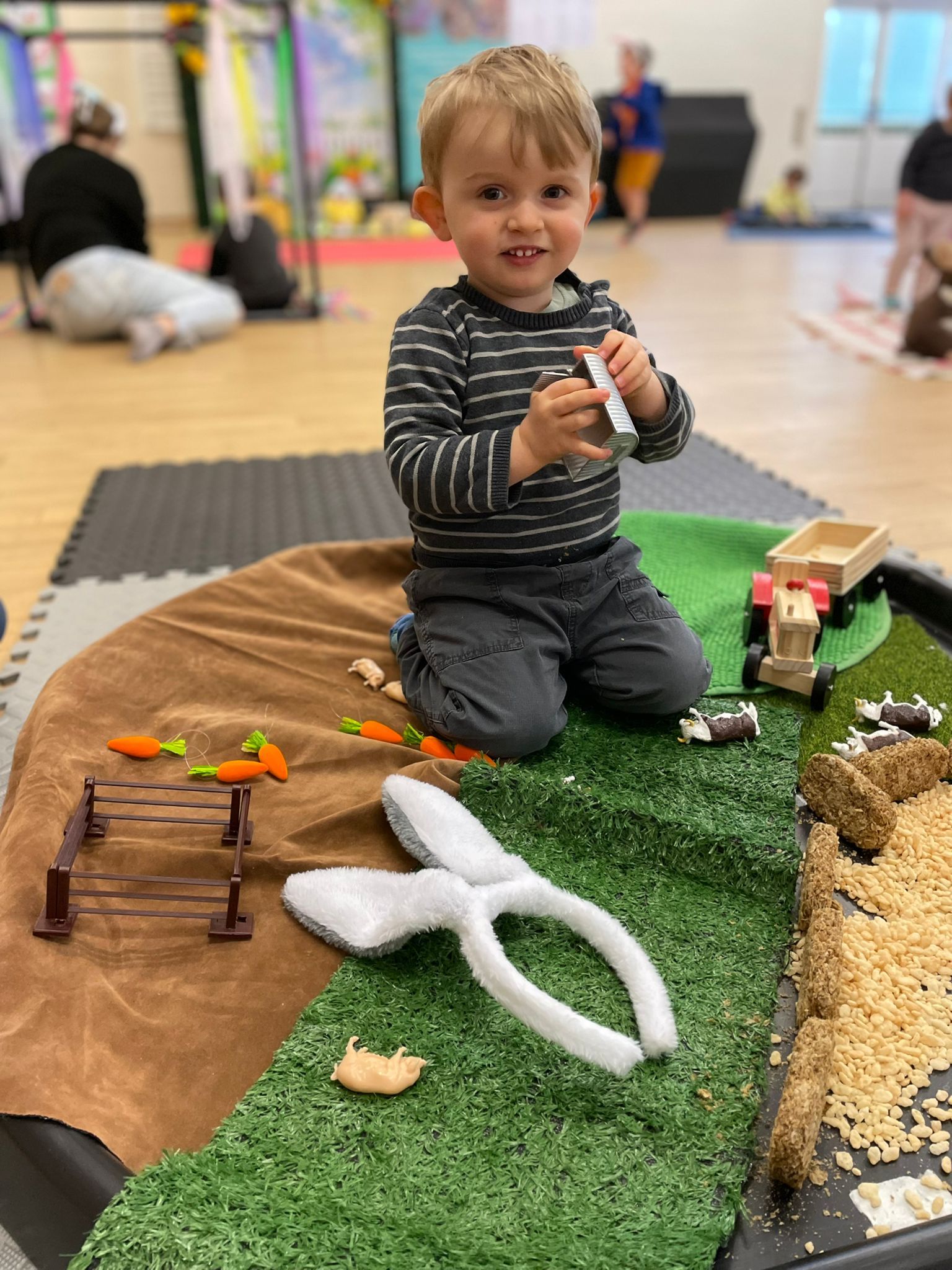A child exploring a farm themed tuff tray 