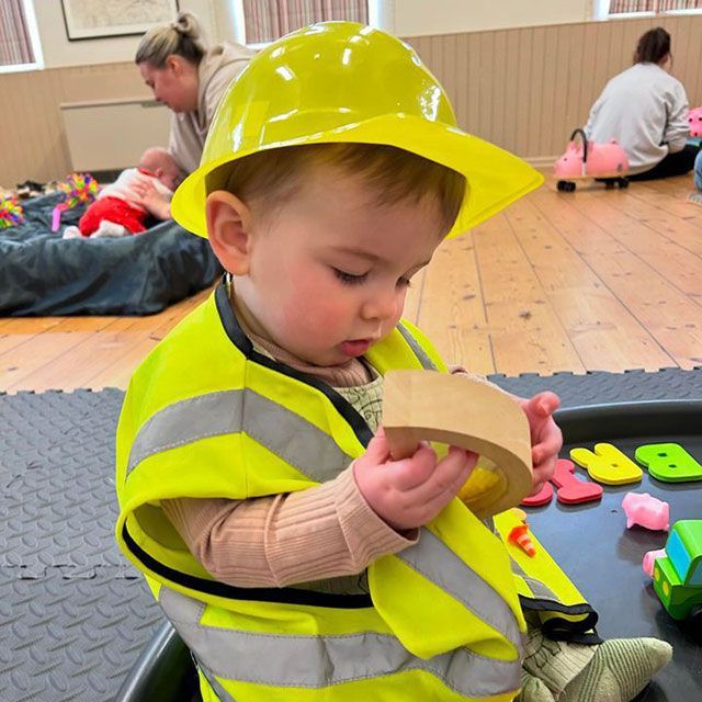a child wearing a builders outfit playing