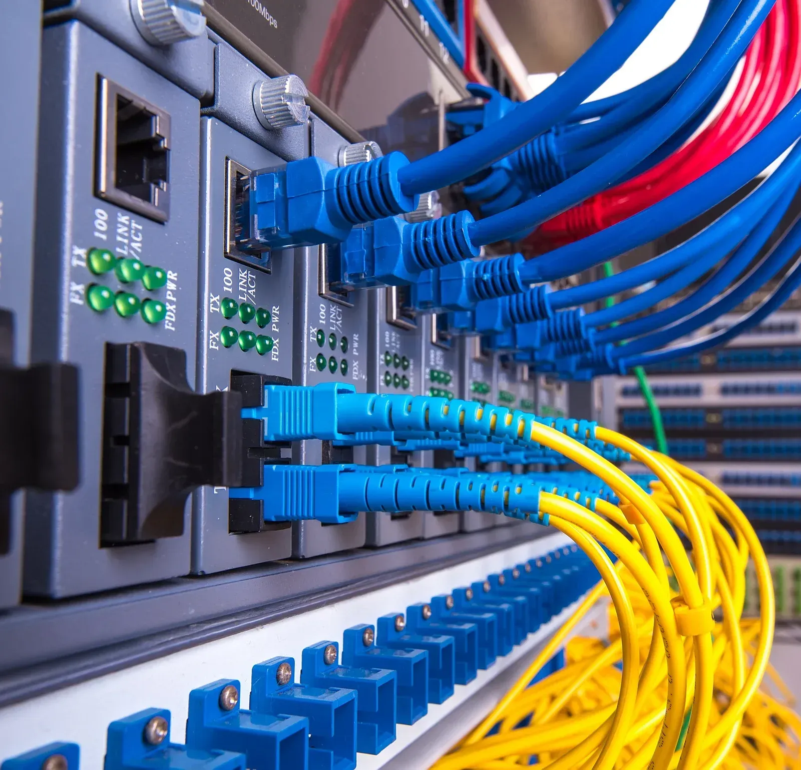 Network switch with blue and yellow Ethernet cables plugged into a server rack