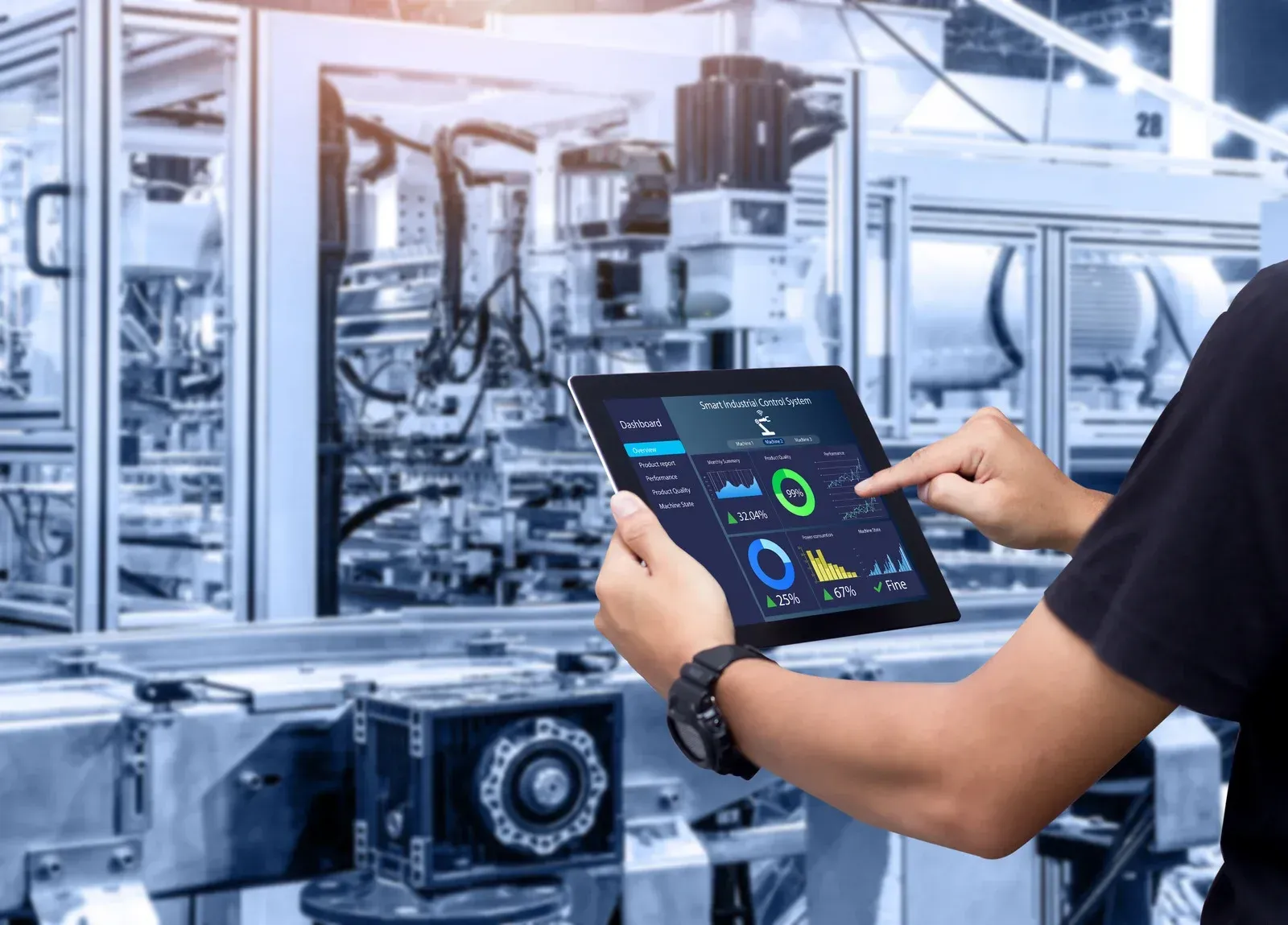 Technician using a tablet to monitor automated machinery in a factory