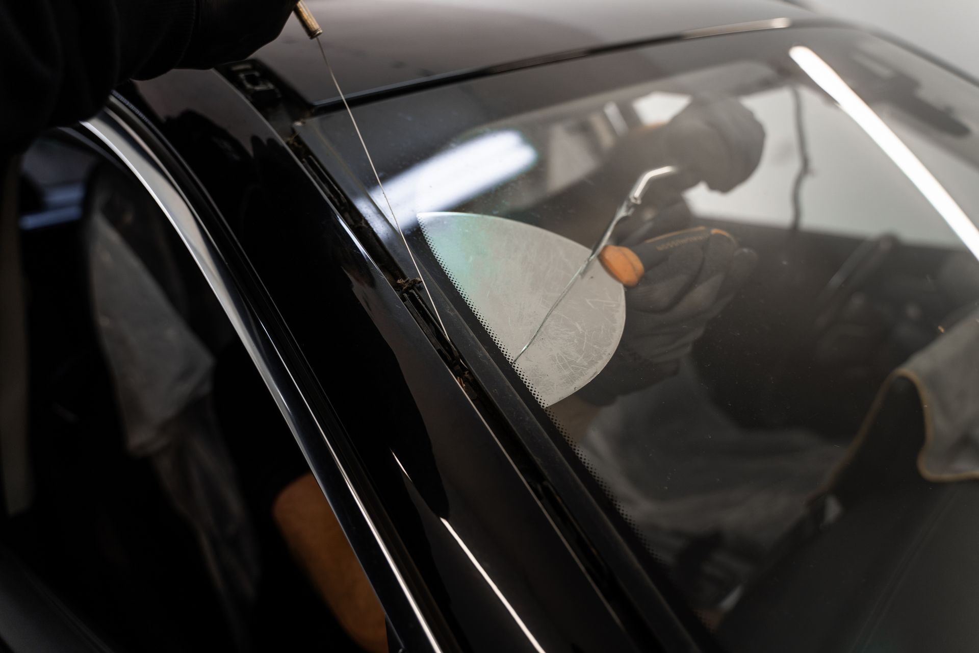 Gray car side mirror next to an open door, reflecting the vehicle interior.