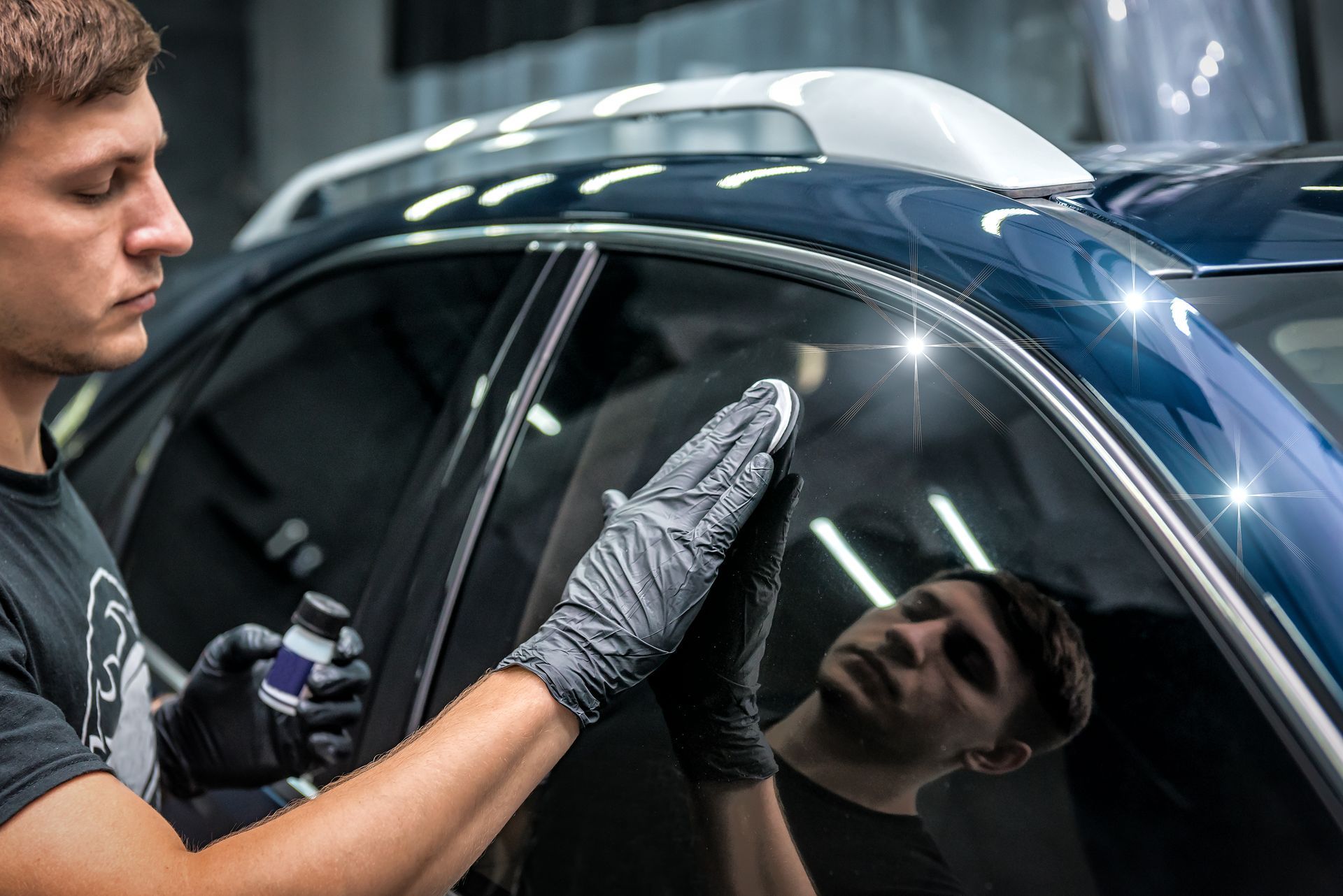 Gray car side mirror next to an open door, reflecting the vehicle interior.