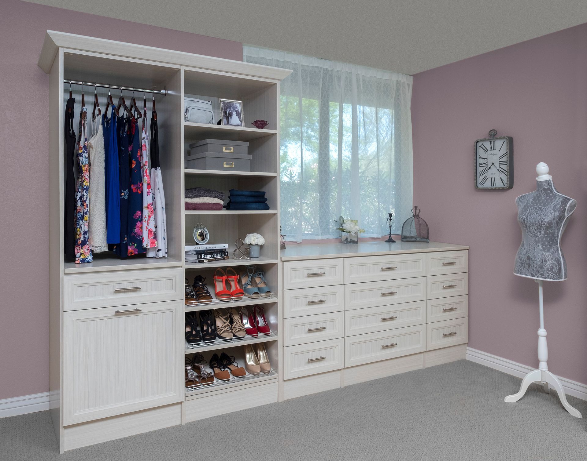 Bright pink bedroom closet with clothes, drawers, shelves, a window, and a dress form mannequin