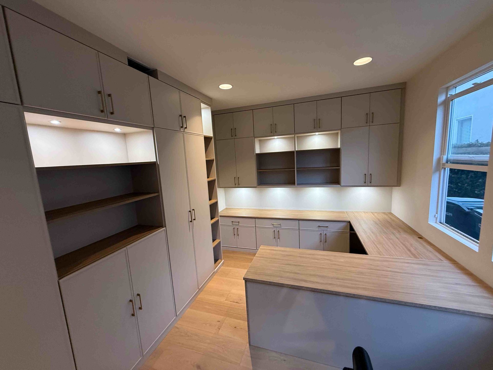 Bright modern kitchen with white cabinets, wood countertops, and a large island.