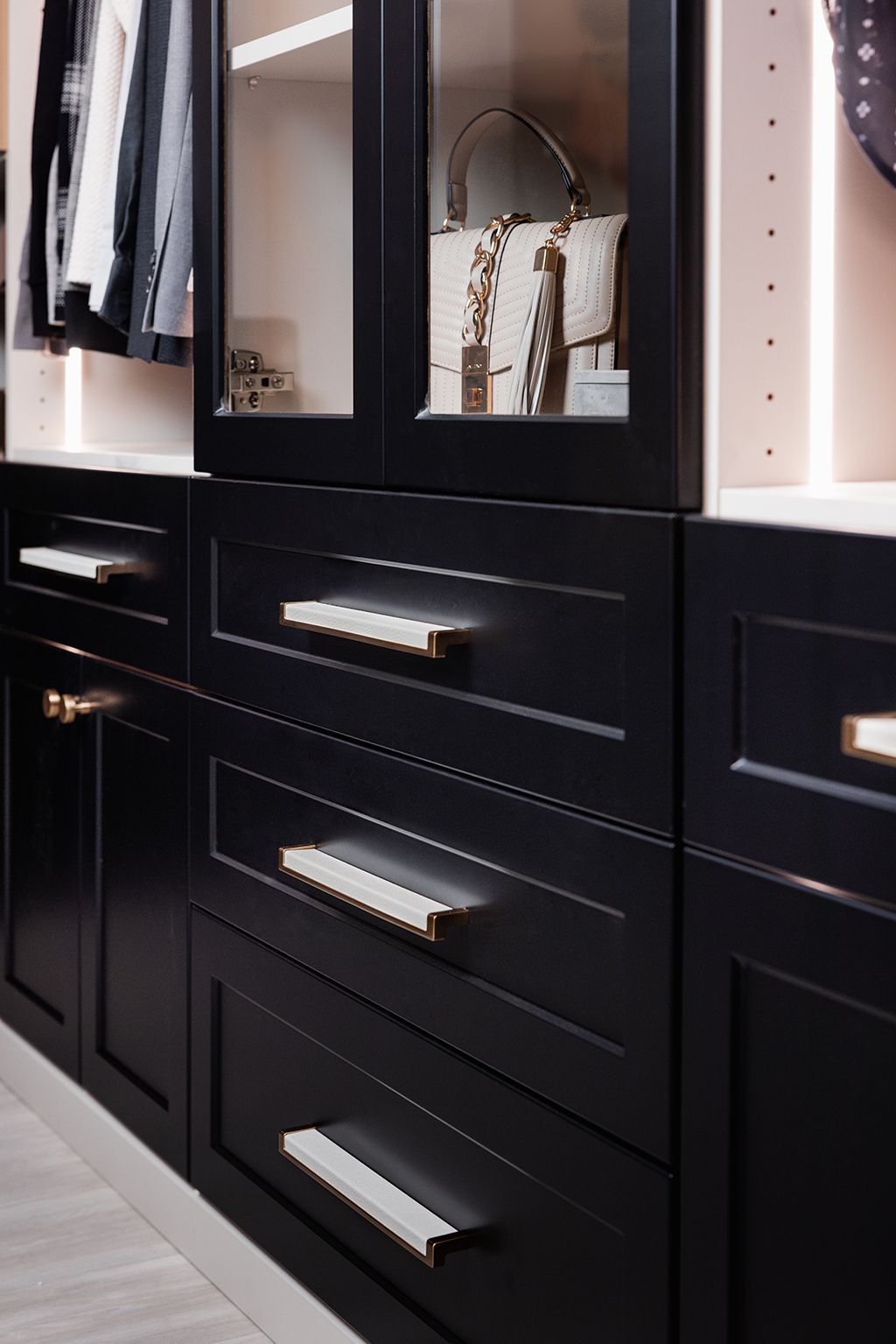 Black built-in wardrobe with glossy cabinet doors and silver handles in a modern room
