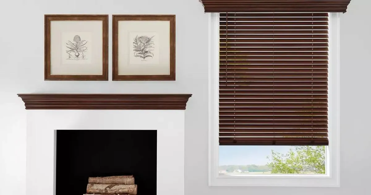 A living room with wood blinds, a fireplace and a window with wooden blinds.