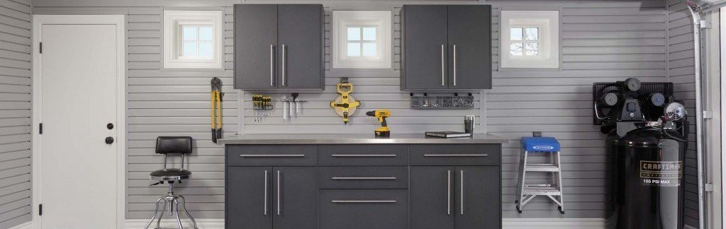 A garage with gray cabinets and a stainless steel counter top.