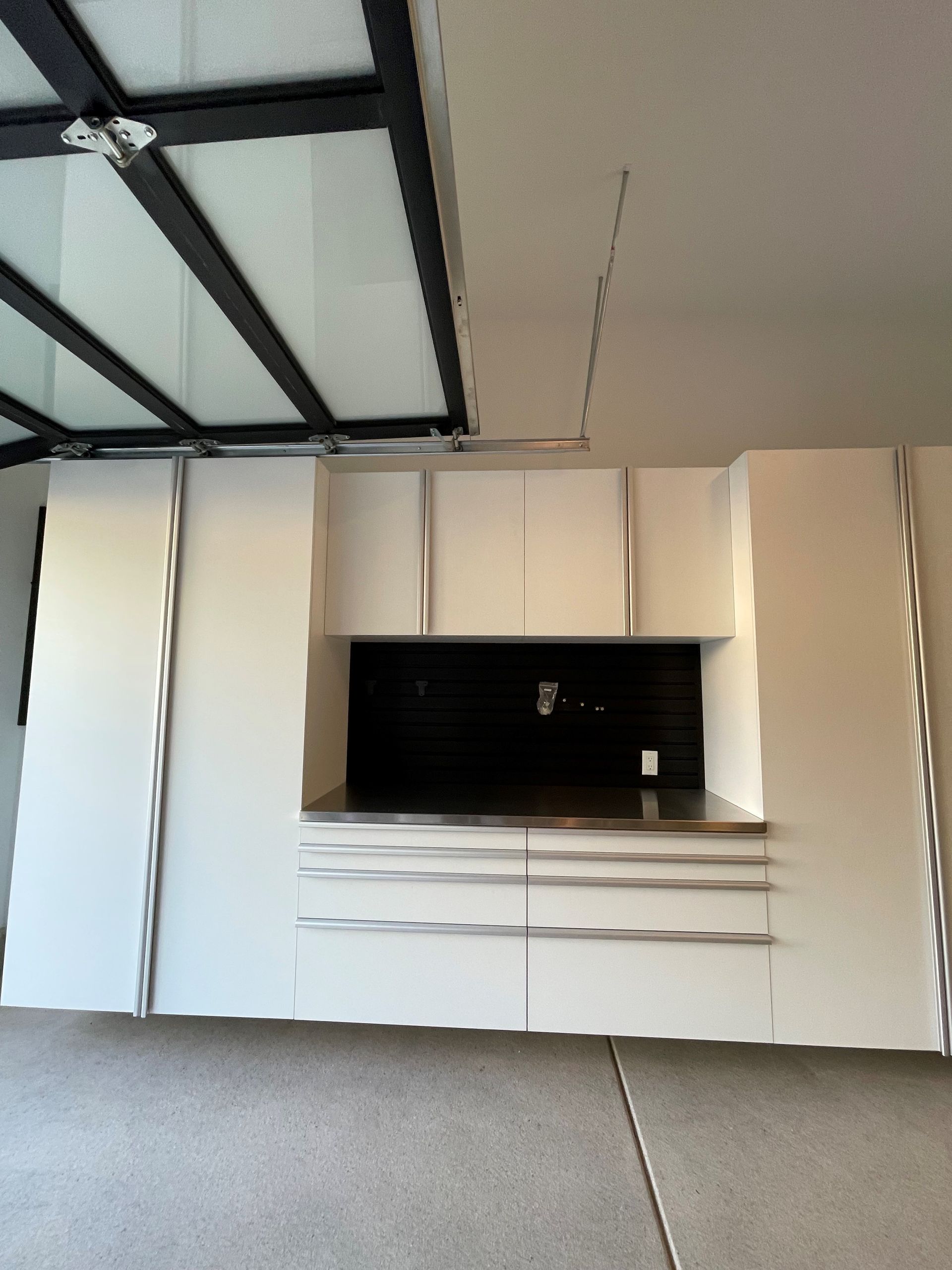 a garage with white cabinets and a ebony star counter top