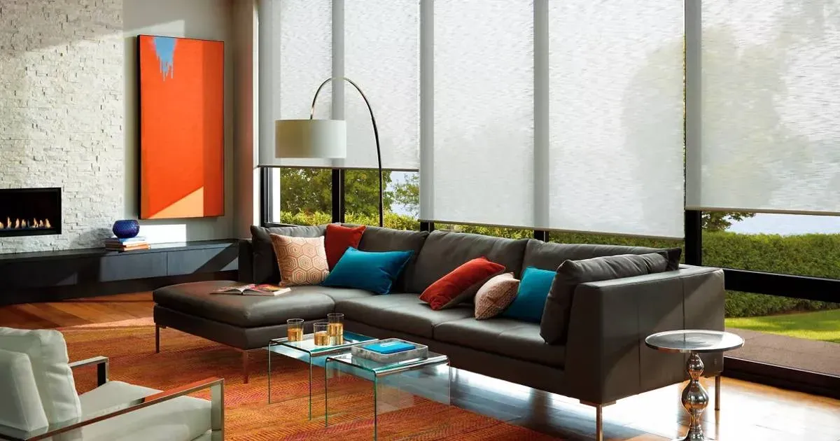 A living room with woven shades a couch and a table