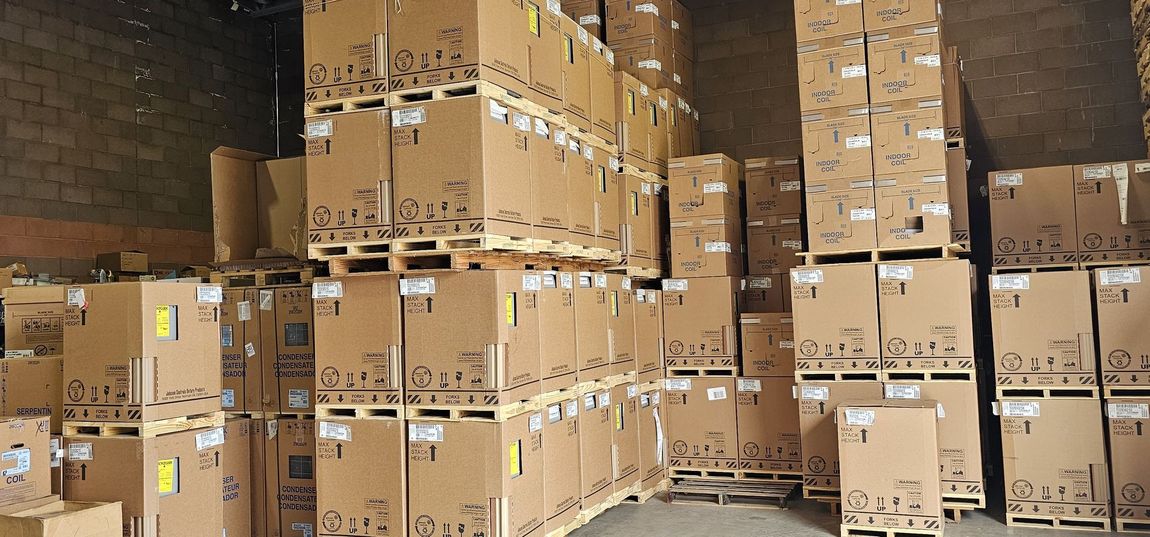Stacks of cardboard shipping boxes piled high in a warehouse loading area