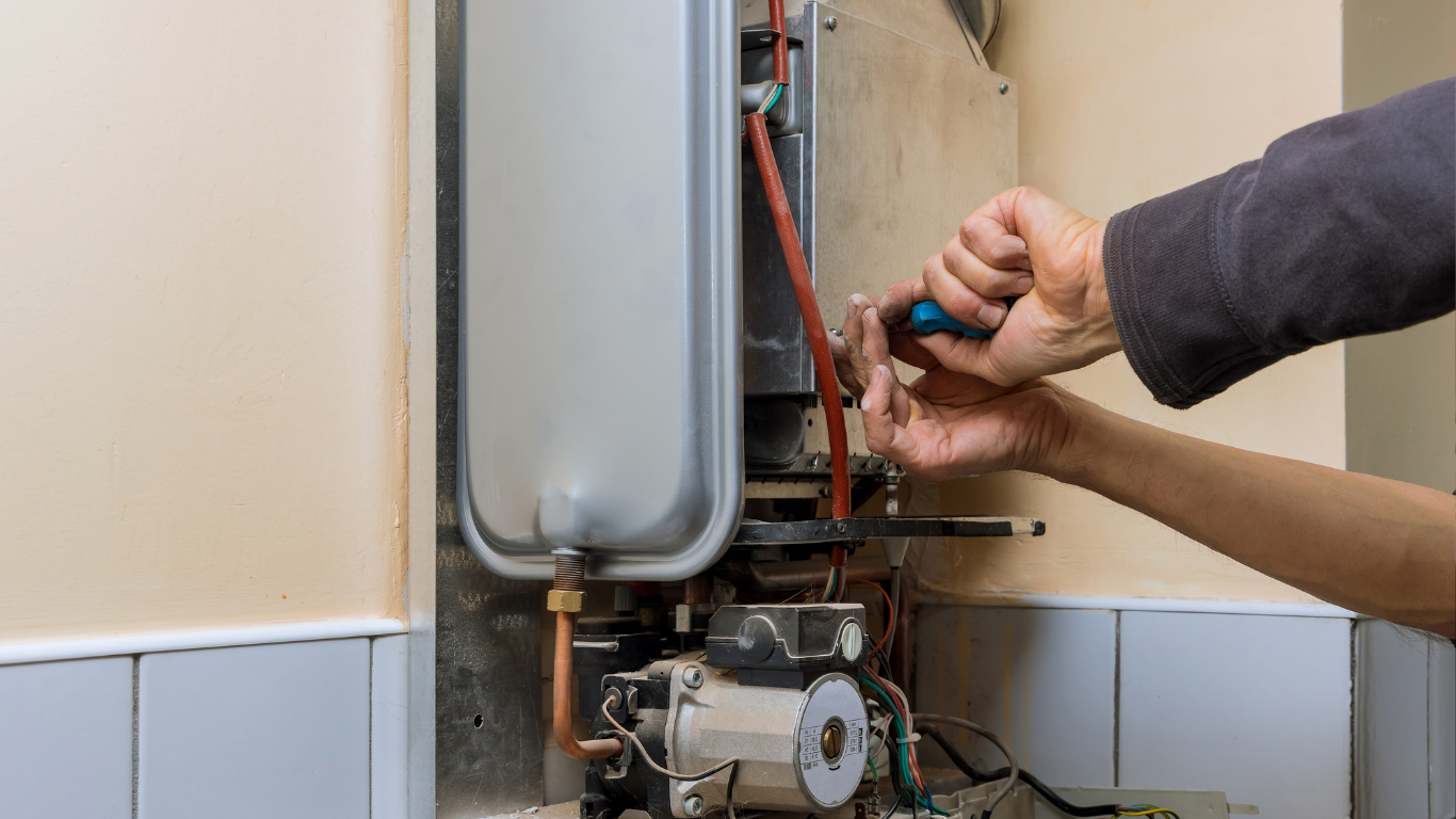 Technician adjusting pipes inside a wall-mounted boiler unit