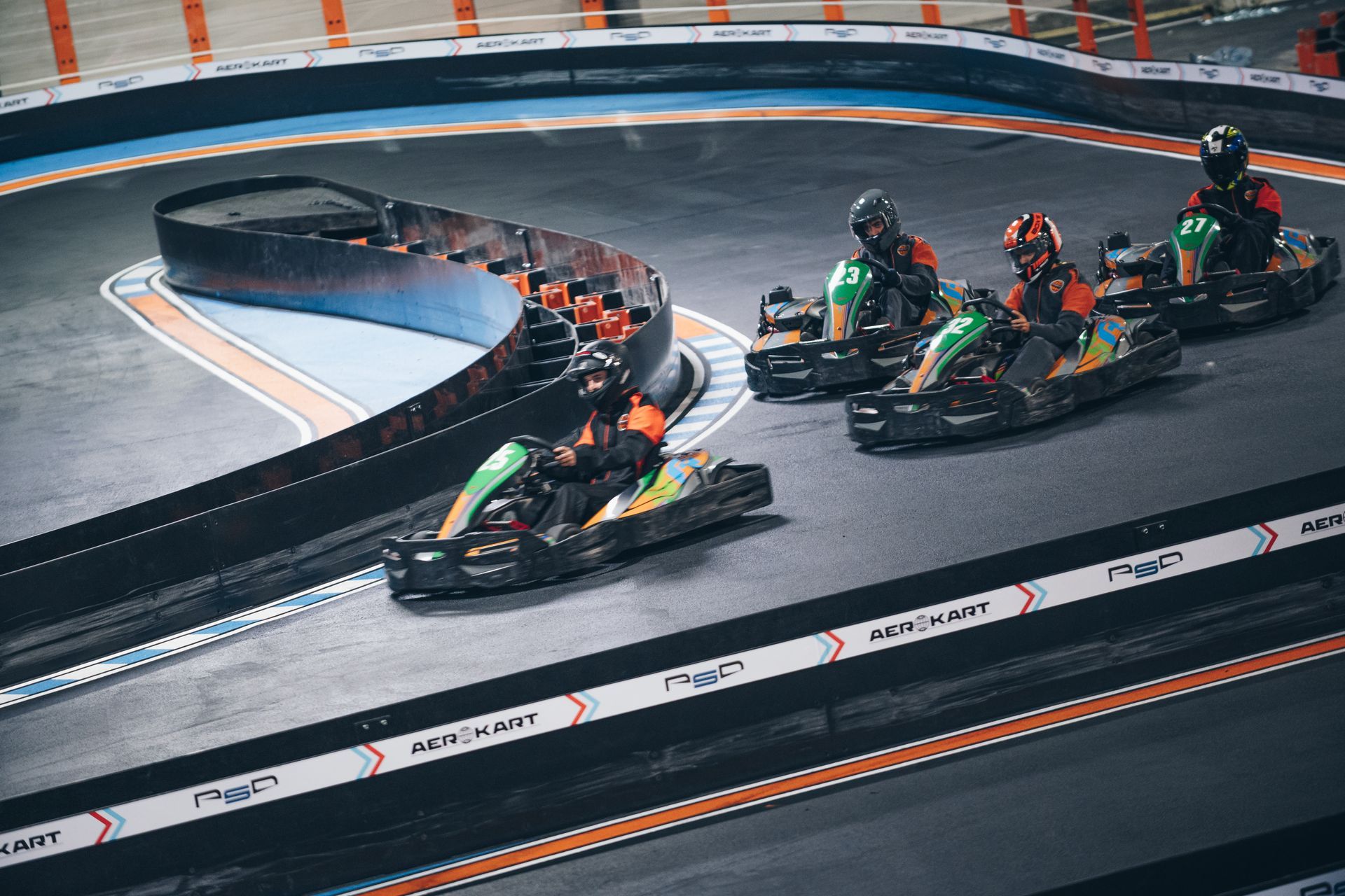 Un groupe de personnes font du kart sur une piste.