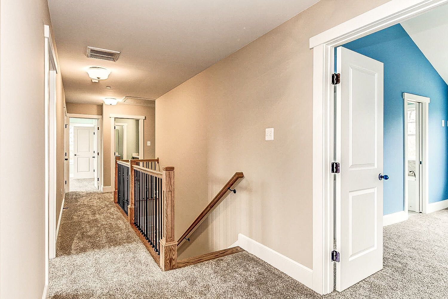 A hallway with stairs leading up to the second floor of a house.