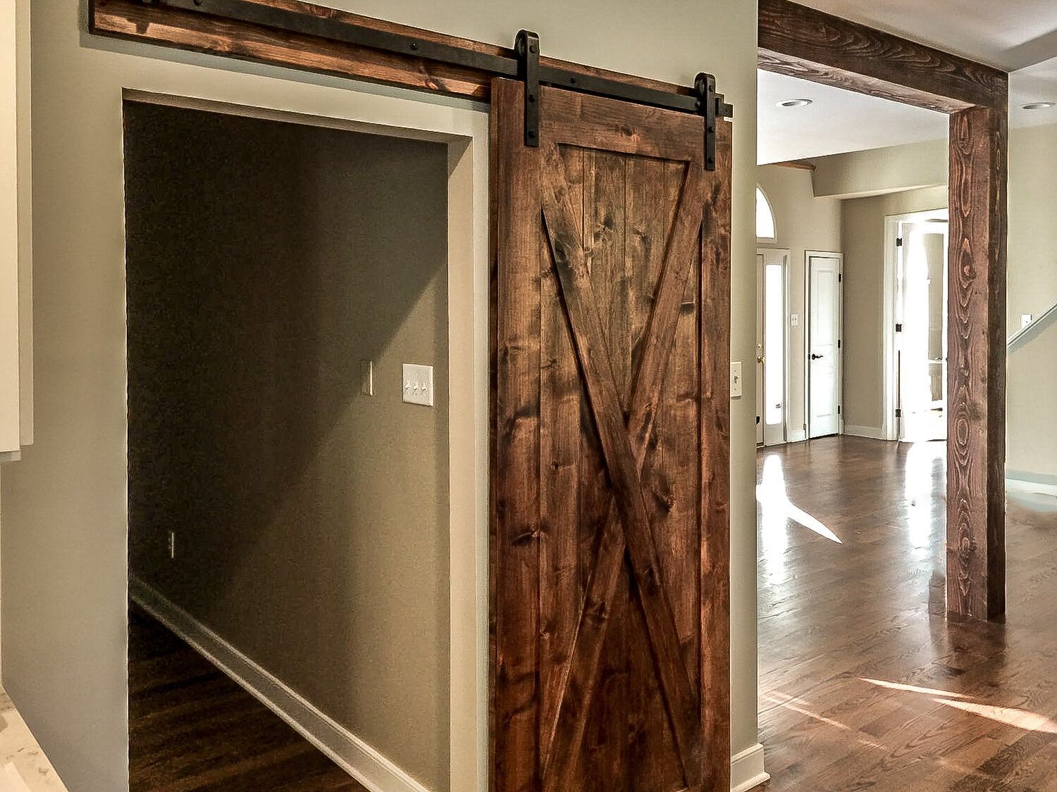 A sliding barn door in a hallway in a house.