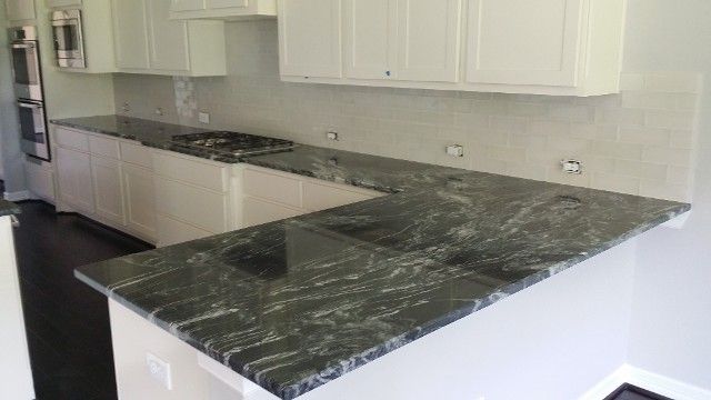 Modern kitchen with white cabinets and dark marble-look countertops