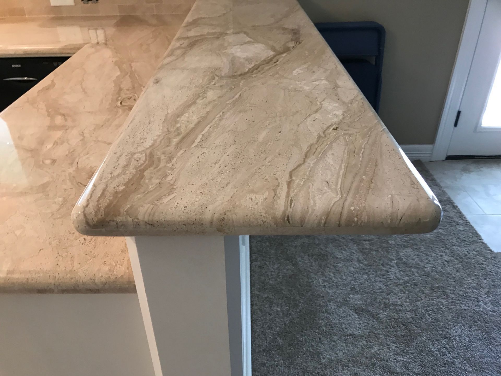 Beige marble tabletop with rounded edges in a kitchen or dining area