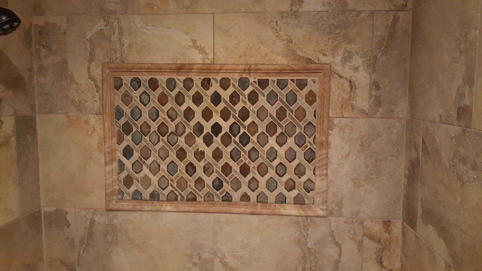Stone floor vent with a metal grille set into tan marble tiles.