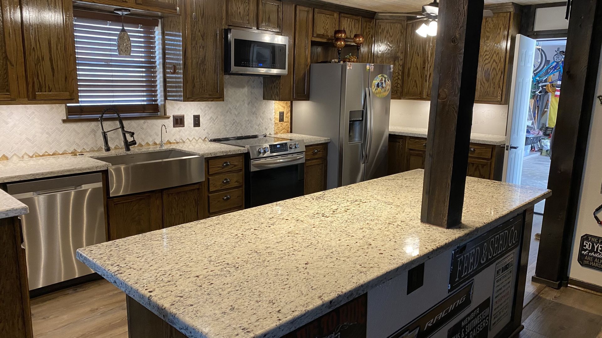 Modern kitchen with granite island, stainless steel appliances, and wood cabinets