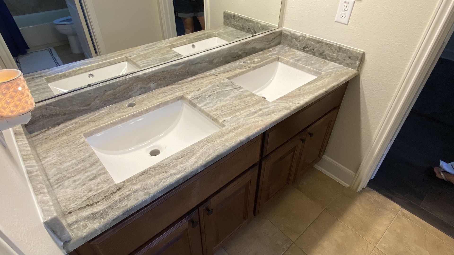 Double vanity bathroom sink with speckled countertop and large mirror, viewed from above.