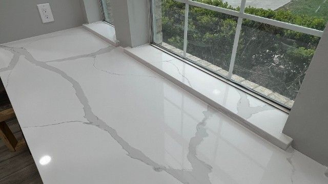 White floor with visible cracks or water-stain lines beside a large window.