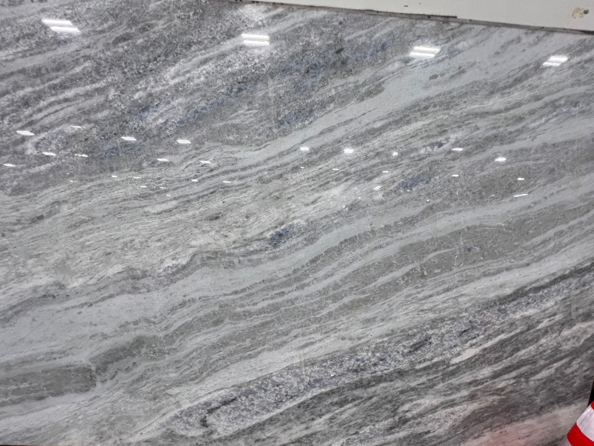 Gray and white marbled stone surface with light streaks and reflections