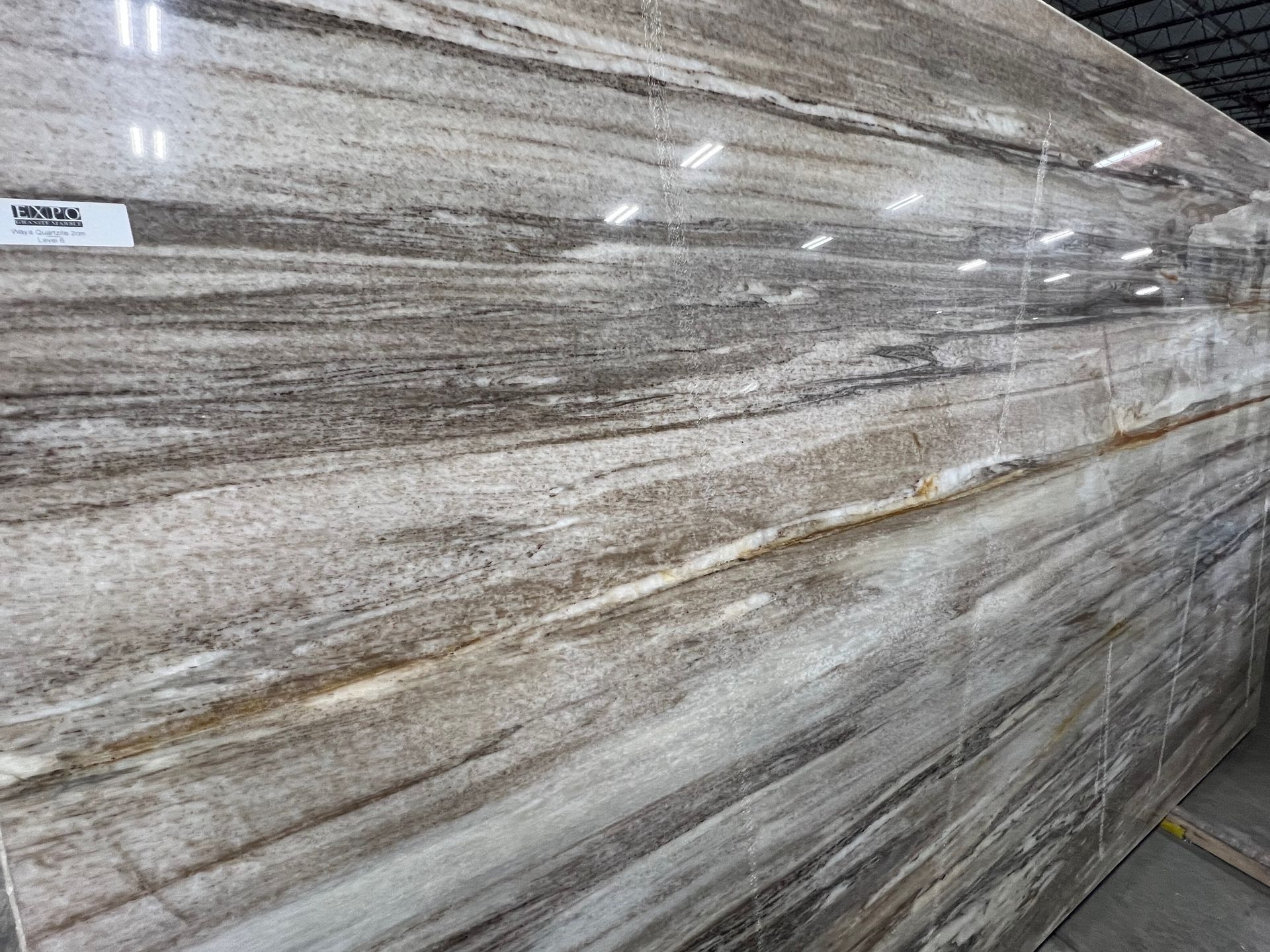 Stacked marble slabs wrapped in plastic inside a warehouse.