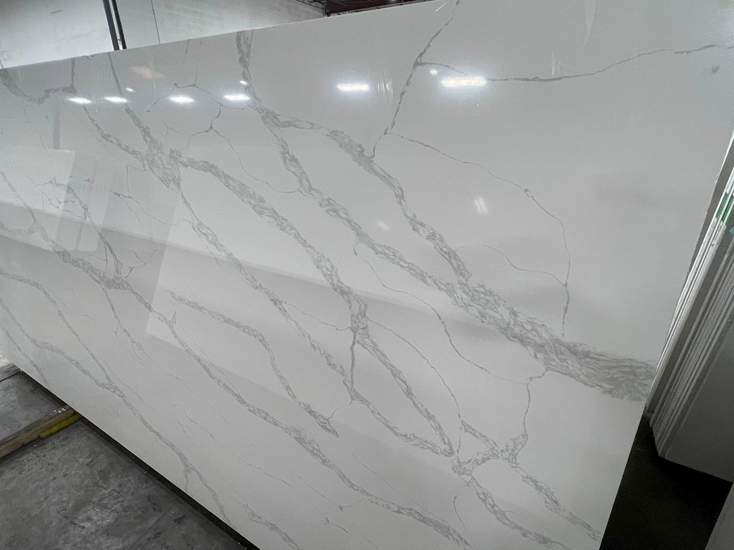 White marble-pattern wall panels with gray veining in an indoor hallway or lobby