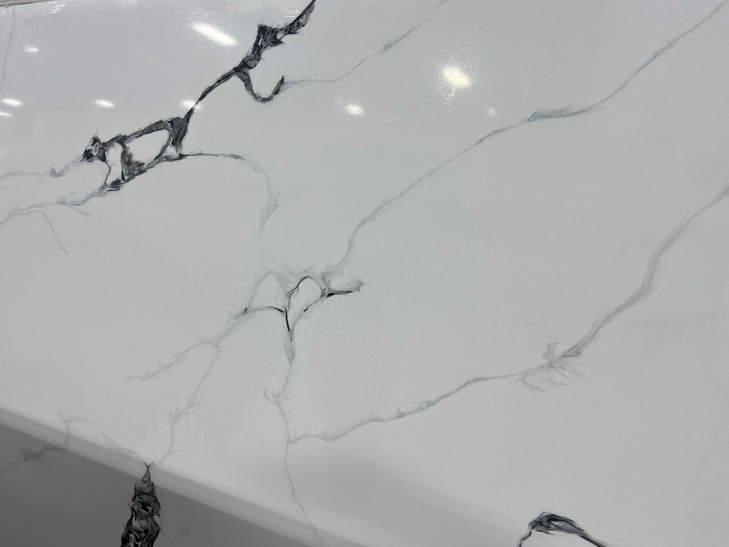 White marble countertop with gray veining and dark cracks near the edge