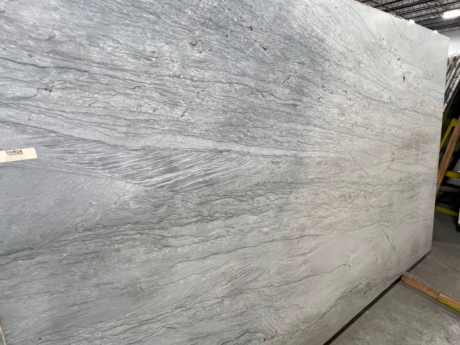 Large gray textured stone slab in a warehouse or workshop setting