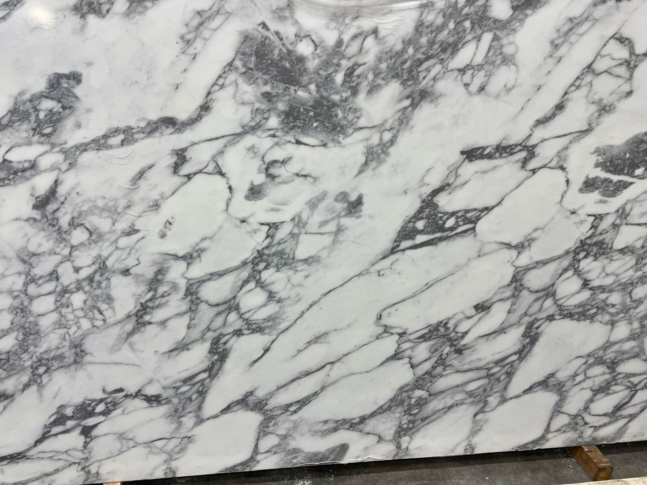 White marble surface with gray veining and a small brown corner at the bottom right